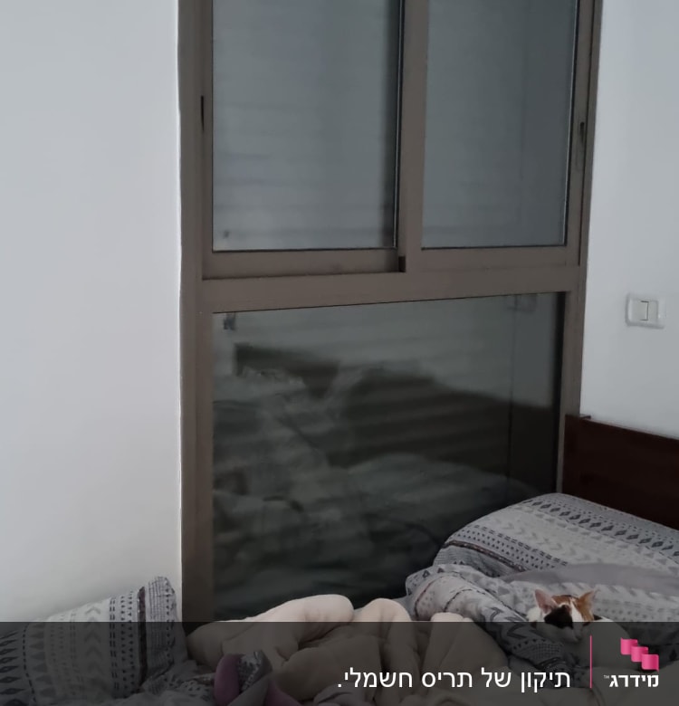 חלון עם תריסים סגורים בחדר שינה